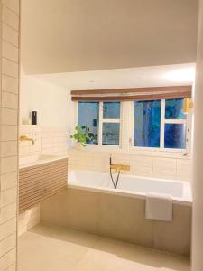 Parkzicht في ليوواردن: حمام أبيض مع حوض استحمام ونافذة