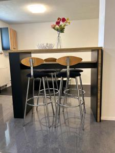 a kitchen with a table and stools with a vase of flowers at Fe Wo Auf der Alb 