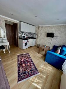 a living room with a blue couch and a kitchen at Elegance Aparts Cihangir in Istanbul
