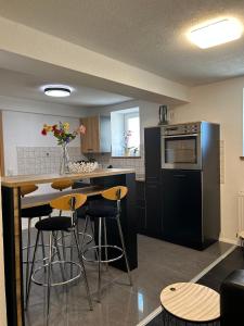a kitchen with black appliances and a table with stools at Fe Wo Auf der Alb 
