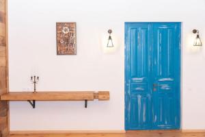 una puerta azul y un banco de madera en una pared en Ethno Sazano Hotel, en Sazano