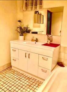 ein Badezimmer mit einem Waschbecken, einem Spiegel und einer Badewanne in der Unterkunft Diggers Dealers Accommodation in Kalgoorlie