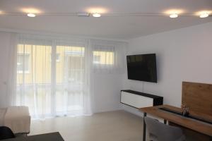 ein Wohnzimmer mit einem Flachbild-TV an der Wand in der Unterkunft Wohnung am Traunsee in Gmunden