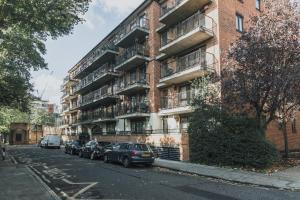 ロンドンにあるStylish Central London Flat with Pool and Terraceのレンガ造りのアパートメントで、車が正面に駐車しています。