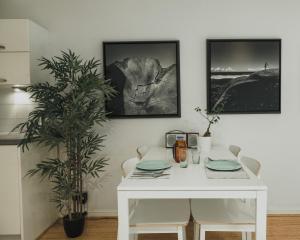 a white dining room table with chairs and a plant at Stylish Central London Flat with Pool and Terrace in London