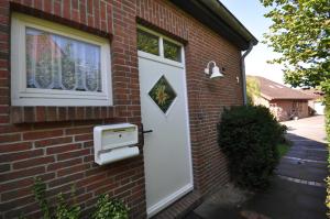 カロリーネンジールにあるNr 98 - Ferienhaus Fischerstraßeのレンガ造りの家の白いドアと郵便受け