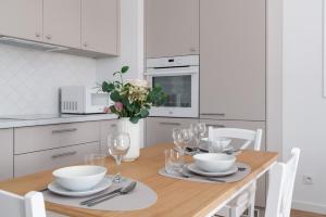 a kitchen with a wooden table with chairs and a dining room at White Elegance Apartment with AC & FREE GARAGE by Renters in Poznań