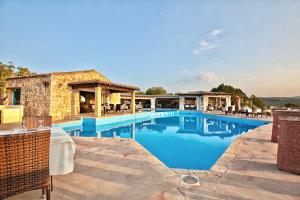 a pool at a resort with tables and chairs at ISA-Residence with swimming-pool in Porto Rotondo at only 500 m from the beach in Porto Rotondo