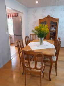a dining room table with a vase of flowers on it at Varakoti Helmeri in Hirvikoski
