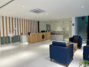 a lobby with blue chairs and a reception desk at Western Suites HiTech City in Hyderabad