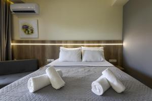 a hotel room with a bed with towels on it at Hotel Yakinthos in Paralia Katerinis
