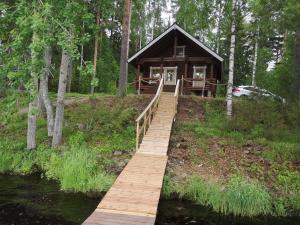 a wooden bridge leading to a cabin in the woods at Honkala Cottage in Keyritty