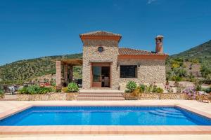 eine Villa mit einem Swimmingpool vor einem Haus in der Unterkunft El Huertecillo by Vintage Travel in El Gastor