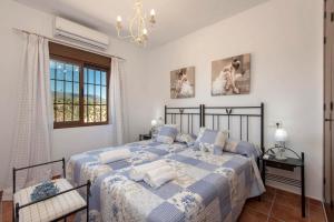 1 Schlafzimmer mit 2 Betten, einem Fenster und einem Kronleuchter in der Unterkunft El Huertecillo by Vintage Travel in El Gastor + 39 Fotos