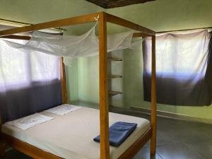 a bedroom with a bunk bed with white sheets at Villa Soa in Hell-Ville