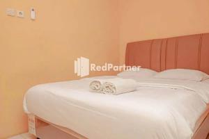 a white bed with two folded towels on it at Pondok Damai Guest House Syariah Mitra RedDoorz in Cirebon
