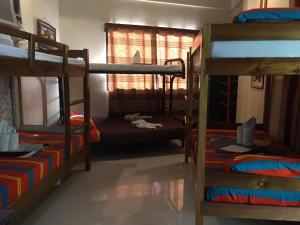 a room with three bunk beds and a window at St. John Island View Pensionne in El Nido