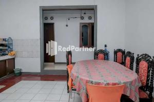 a dining room with a table with orange chairs at Pondok Damai Guest House Syariah Mitra RedDoorz in Cirebon