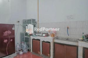 a kitchen with a red perimeter sign on the wall at Pondok Damai Guest House Syariah Mitra RedDoorz in Cirebon +13 photos