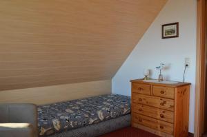 ザスニッツにあるFerienhaus Wagnerのベッドルーム1室(ベッド1台、木製ドレッサー付)