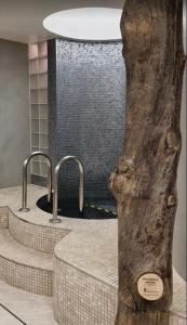 un bagno con tre lavandini e un tronco d'albero di Bitcoin Adorabile suite nel cuore del magnifico Chiswick a Londra