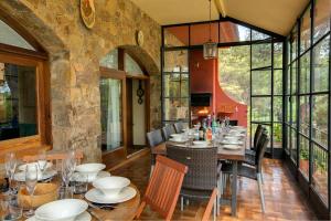 ein Esszimmer mit Tischen und Stühlen und Fenstern in der Unterkunft Can Perals by Vintage Travel in Tamariu