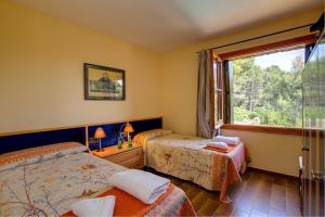 ein Hotelzimmer mit zwei Betten und einem Fenster in der Unterkunft Can Perals by Vintage Travel in Tamariu + 19 Fotos