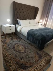 - une chambre avec un lit doté d'une grande tête de lit et d'un tapis dans l'établissement Rondebosch East Garlandale STRICTLY HALAAL, fresh garden cottage, au Cap 27 autres photos