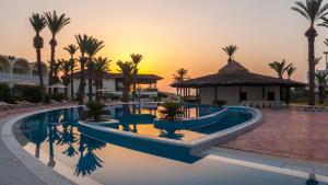 una piscina del resort con palme e gazebo di Hotel Marhaba Club a Sousse