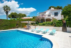 una piscina con sillas y una casa en el fondo en Villa Sophia, en Tamariu