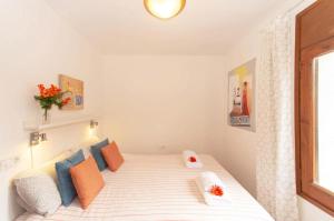 1 dormitorio con 1 cama con almohadas de color naranja y azul en Villa Sophia, en Tamariu