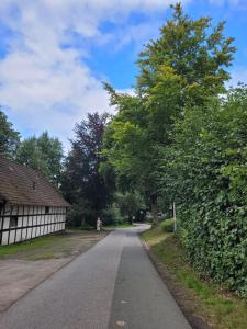 un camino vacío con un edificio y árboles en Tiemann, en Preußisch Oldendorf