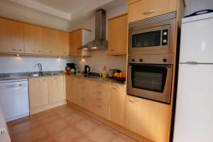 eine Küche mit Holzschränken und Geräten aus Edelstahl in der Unterkunft Casa Verity by Vintage Travel in Tamariu