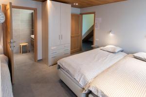 a bedroom with a large bed and a bathroom at heyzerhof in Poperinge