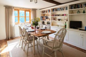 een eetkamer met een houten tafel en stoelen bij Church Cottage in Halesworth