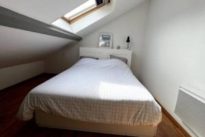 a small bedroom with a bed in a attic at La bonne pioche - centre et plage in Wimereux