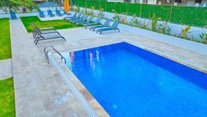 a swimming pool with lounge chairs and a swimming pool at Der Inn Hotel Lara in Antalya