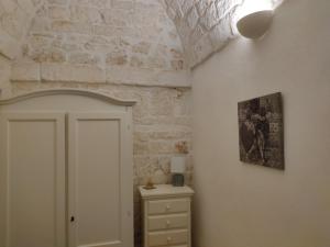 Cette chambre est dotée d'une porte blanche et d'un mur en briques. dans l'établissement I due cuori, à Ostuni