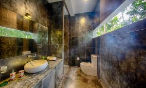 a bathroom with a sink and a toilet at Wild Nest Villa Unawatuna in Unawatuna