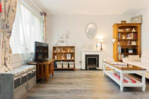 a living room with a couch and a tv at Snug & Cosy Home In Thamesmead Overlooking A Park in Thamesmead