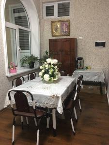 uma mesa de jantar com um vaso de flores em Гостевой дом AL XALIL em Samarkand