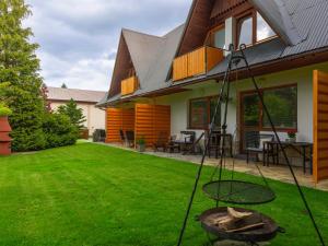 una casa con un patio con un columpio en Modrzew en Zakopane