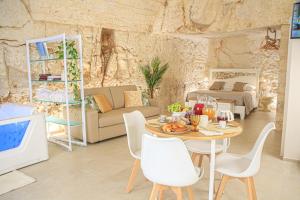 un soggiorno con un tavolo e un divano di GB Grotta Bianca a Ostuni