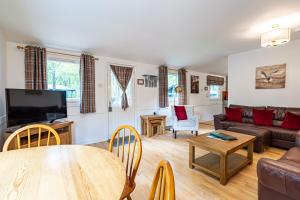 a living room with a table and a couch at Heather Lodge 3 with Hot Tub in Belladrum