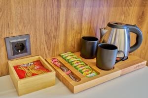 a tray with a coffee pot and a box of snacks at Der Inn Hotel Lara in Antalya