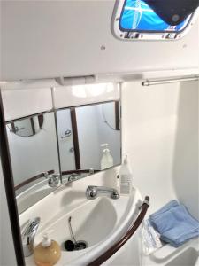 y baño con lavabo y espejo. en bnsail barca a vela per crociere, veleggiate o semplice relax a bordo, en Porto