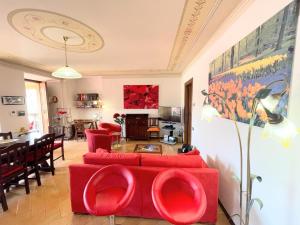 a living room with a red couch and a dining room at Spoleto trendy - Central apartment surrounded by shops in Spoleto