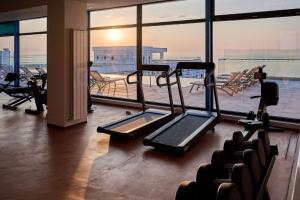 um ginásio com equipamento cardiovascular e uma grande janela em Infinity Breezes Apartment Beach Resort - parking em Mamaia