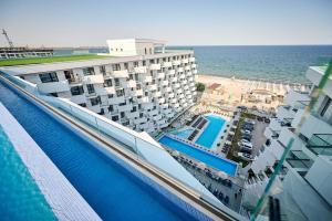 un hotel con piscina vicino all'oceano di Infinity Breezes Apartment Beach Resort - parking a Mamaia