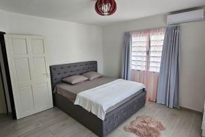 a bedroom with a large bed and a window at Paradijs in Paramaribo in Paramaribo